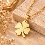 Close up view of stainless steel four leaf clover charm necklace with gold tone finish