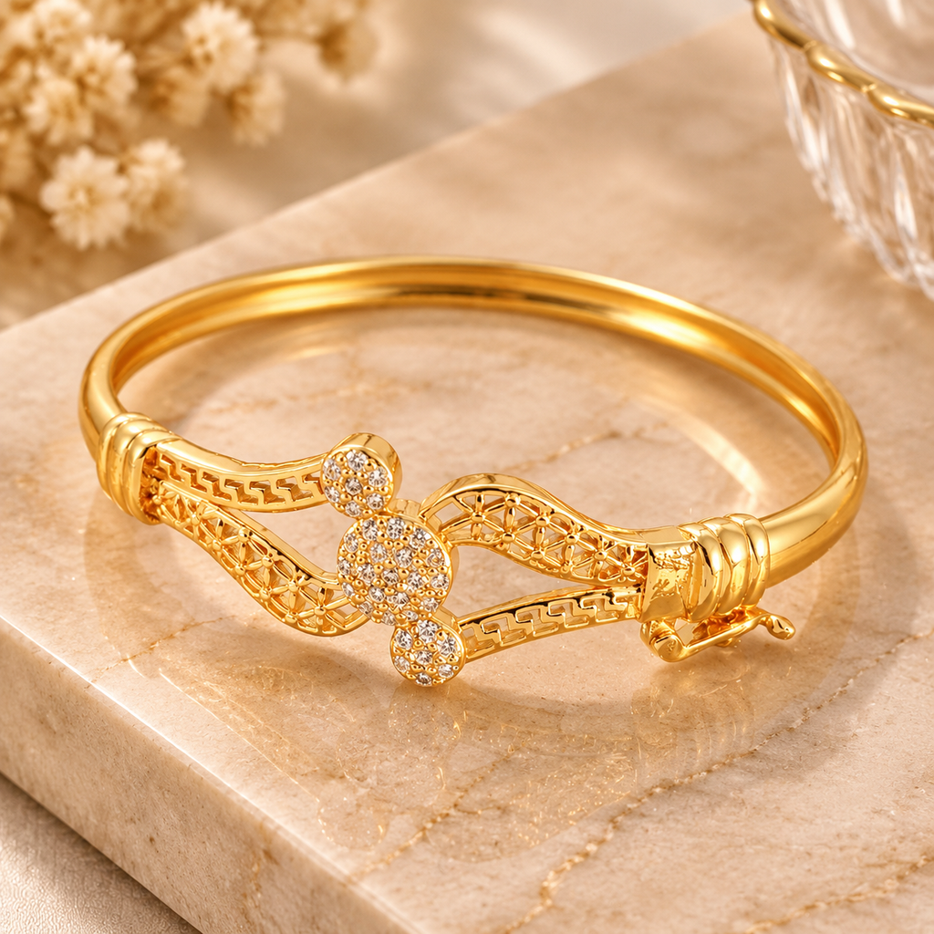 Gold tone geometric bracelet side angle view with crystal style details and polished finish