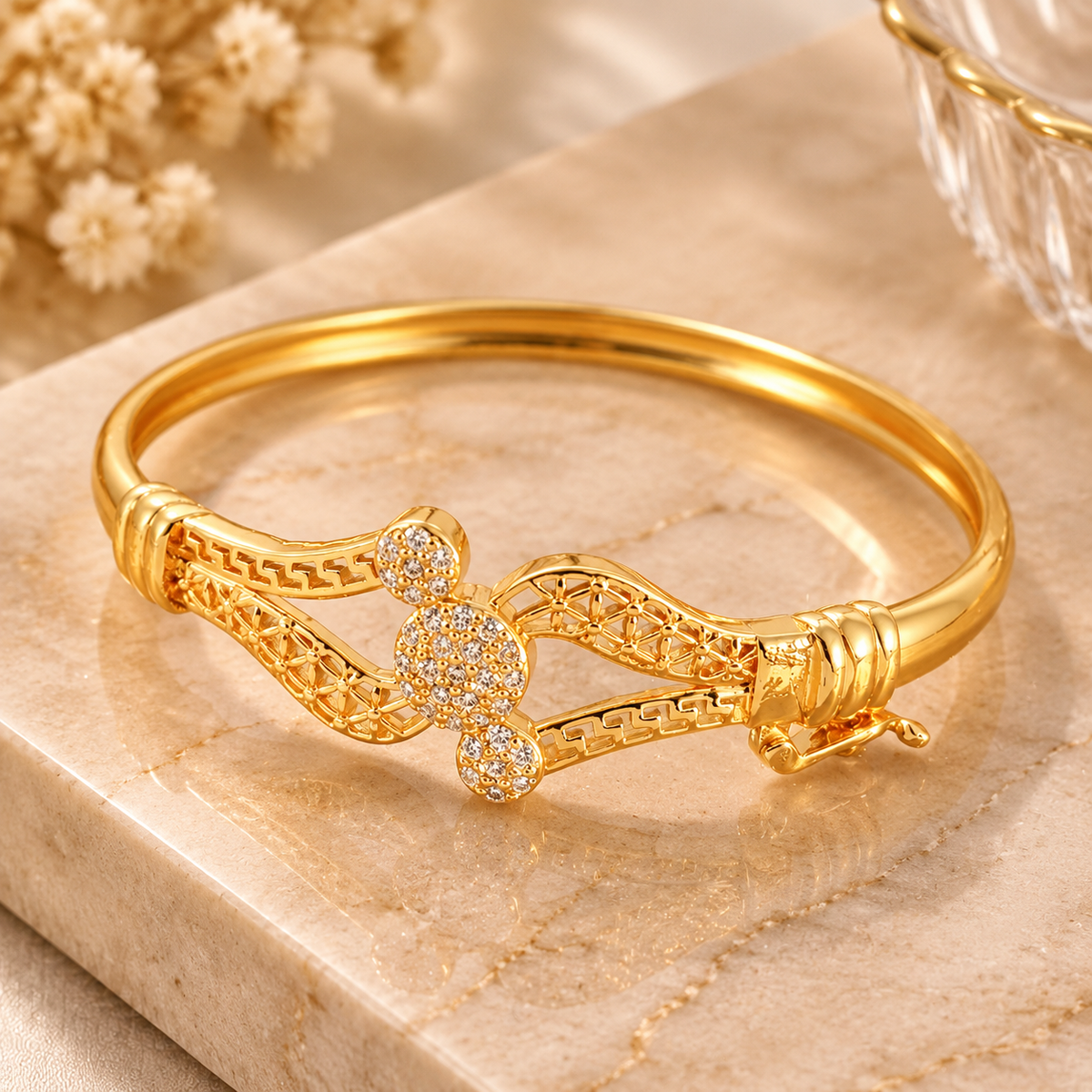 Gold tone geometric bracelet side angle view with crystal style details and polished finish