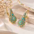 Turquoise crystal drop earrings with gold-tone finish and elegant statement design