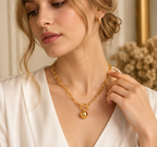 Woman wearing gold tone stainless steel paperclip chain necklace with minimalist sphere pendant