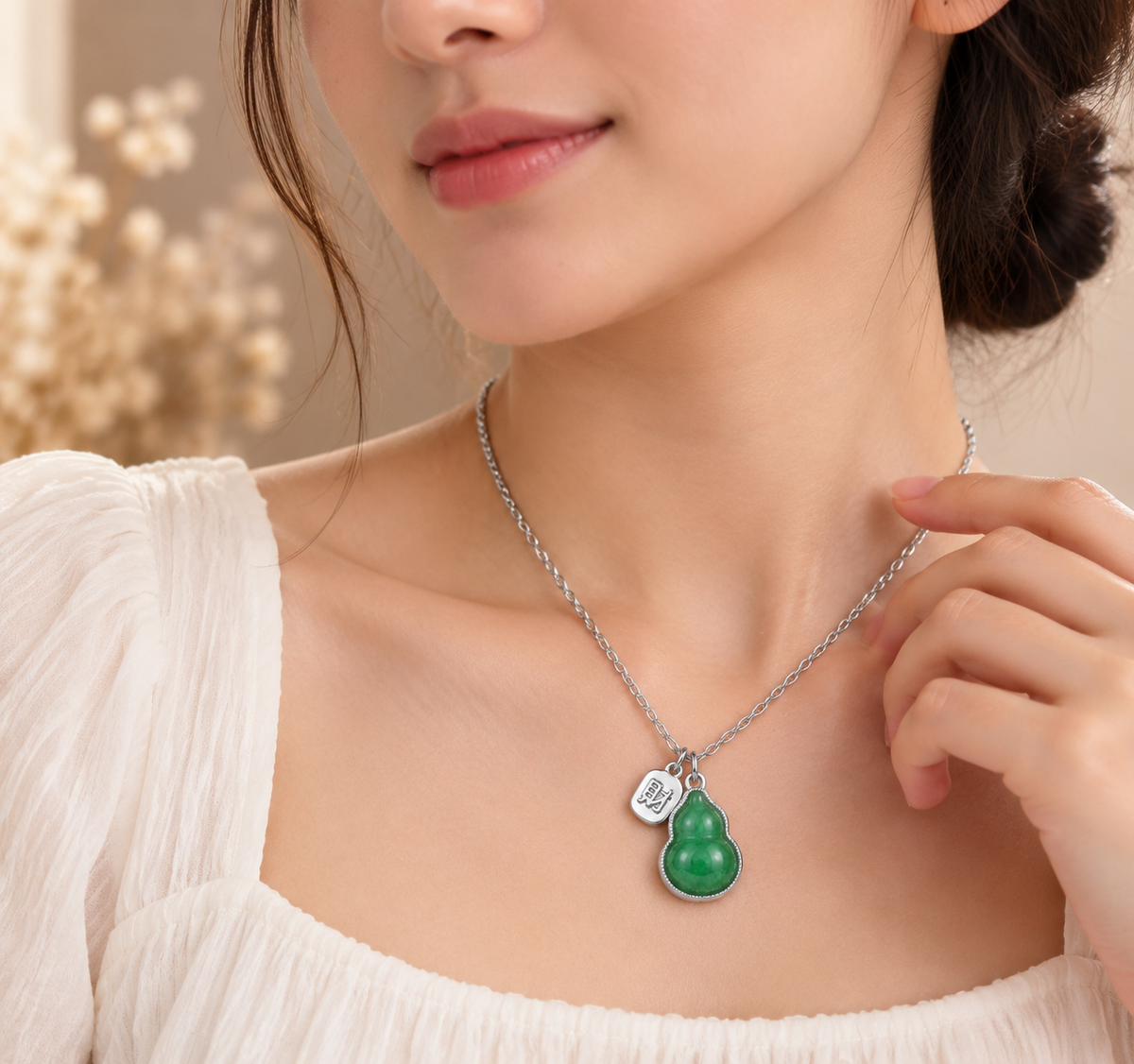 Woman wearing green gourd pendant necklace with elegant silver tone fashion jewelry design